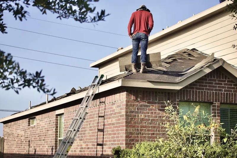 Professional roofer working on a residential roof in Ashbox